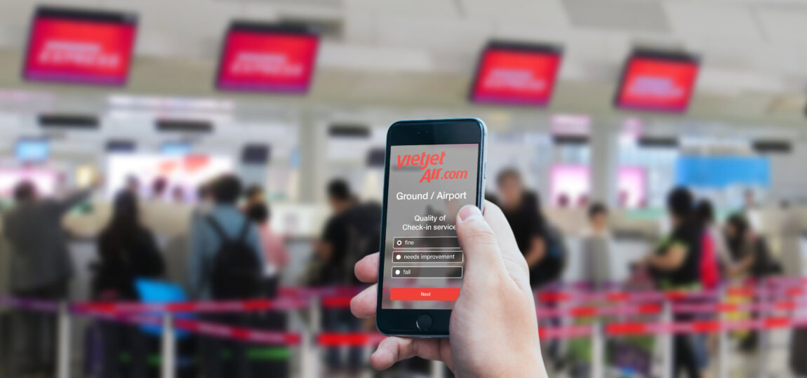 Dank Multi-Channel Befragungsmethode erreicht Vietjet Air seine Passagiere an allen Touchpoints und erhält wertvolles Feedback zur Steigerung der Service-Qualität. Smartphone mit Zufriedenheitsbefragung von Vietjet